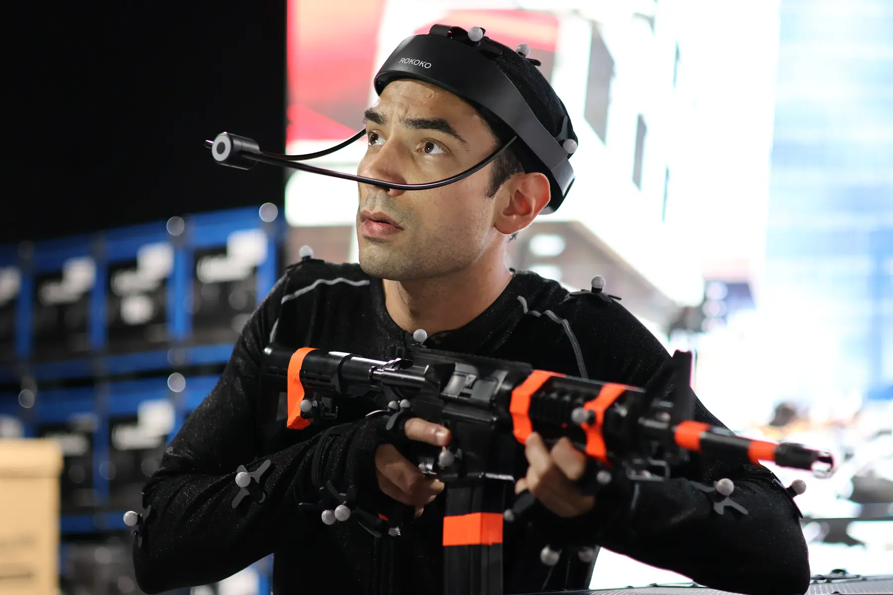 Performer in mocap suit with prop weapon and head cam